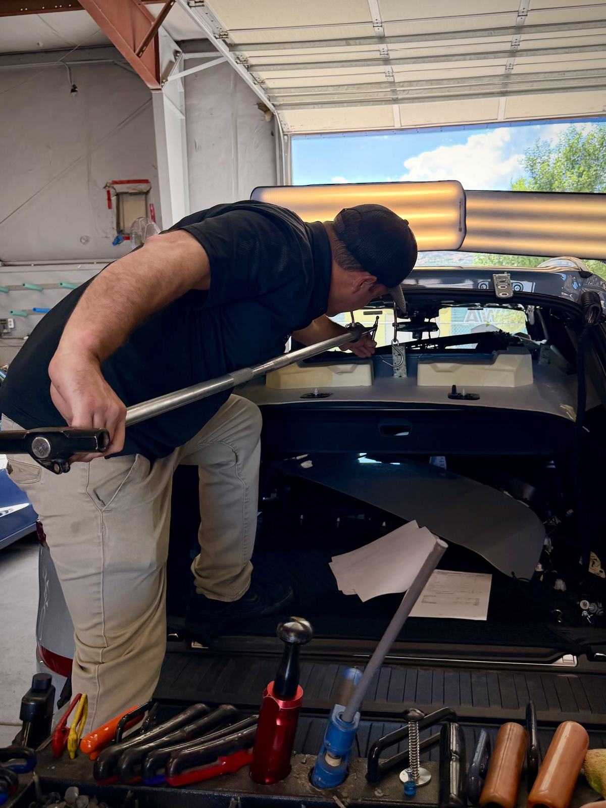 Technician using door access bar for paintless dent repair Colorado Springs
